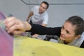 Female reaching grip on climbing wall