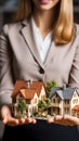 Female real estate agent holding a model family house in her hands Royalty Free Stock Photo