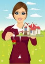 Female real estate agent holding a model house