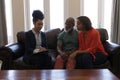 Female real estate agent and senior couple discussing over clipboard in living room Royalty Free Stock Photo