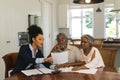 Female real estate agent and senior couple discussing over documents Royalty Free Stock Photo