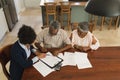 Female real estate agent and senior couple discussing over documents Royalty Free Stock Photo