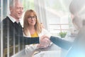 Female realtor giving handshake to happy senior couple after successful agreement  multiple exposure Royalty Free Stock Photo