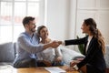 Realtor handshaking with couple after signing rental agreement Royalty Free Stock Photo
