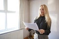 Female Realtor Looking At House Details In Property For Renovation