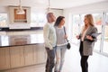 Female Realtor Showing Couple Interested In Buying Around House Royalty Free Stock Photo