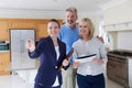 Female Realtor Showing Mature Couple Around House