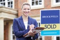 Portrait Of Female Realtor Standing Outside Residential Property