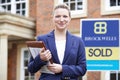 Female Realtor Standing Outside Residential Property