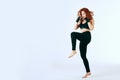 Female red-haired boxer in black sportswear posing on white background Royalty Free Stock Photo