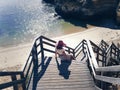 Female in a red hat on the wooden steps of the stairs on the beach in Portugal Royalty Free Stock Photo