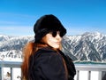 Female redhead model wearing fashion winter clothing looking back at the camera while standing in front of a stunning landscape Royalty Free Stock Photo