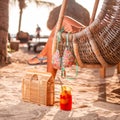 Female relaxing on a wicker seat next to a Colorful Michelada Cocktail drink on sandy beach Royalty Free Stock Photo