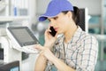 female repairer on phone fixing printer Royalty Free Stock Photo