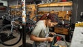Female repairman fixing bike tube in workshop