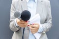 Female journalist holding microphone during media interview. Freedom of the press concept. Royalty Free Stock Photo