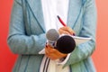 Female journalist at news conference, writing notes, holding microphone Royalty Free Stock Photo