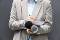 Female journalist at news conference or media event, writing notes, holding microphone Royalty Free Stock Photo