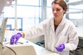 Female researcher loading samples in centrifuge in laboratory Royalty Free Stock Photo