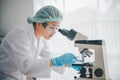 Female researchers are experimenting with pipette dropping a sample into a test tube in an experiment research in laboratory