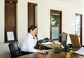 Female resort receptionist working at the front desk Royalty Free Stock Photo