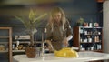 A female restorer painting a yellow detail in workshop. Lense flare