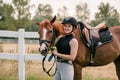 Rider in equestrian clothes holding the reins and leading horse, side view Royalty Free Stock Photo