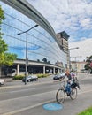 Female riding city bicycle with baby in bicycle chair on the bicycle path, against the background of modern glass building Royalty Free Stock Photo