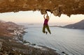 Female rock climber on challenging route in cave at sunset Royalty Free Stock Photo