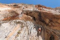 Female rock climber on handholds on challenging route on cliff