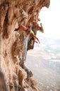 Female rock climber resting while hanging on rope