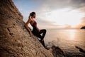 Female rock climber watching sunset over sea Royalty Free Stock Photo