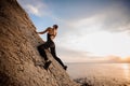 Female rock climber watching sunset over sea Royalty Free Stock Photo