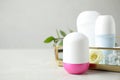 Female roll-on deodorants on white wooden table against grey background