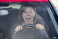 Female rookie new driver young beautiful woman scared and stressed while driving car in fear and shock