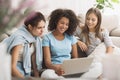 Female roommates surfing internet on laptop at home