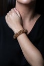 Female, rose gold wicker bracelet in the shape of a spring on hand, on a black background. Royalty Free Stock Photo