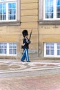 Female royal guard in elegant royal life guards uniform walks with rifle at Amalienborg Castle