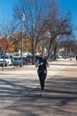 Female runner in a dark sweater on the sidewalk in downtown Washington