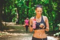 Sportswoman using smartphone app and walking on running track in the park. Royalty Free Stock Photo