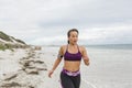 Female runner jogging during outdoor workout on the beach Royalty Free Stock Photo