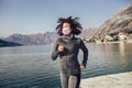 Female runner jogging with protective mask during outdoor workout on beach Royalty Free Stock Photo