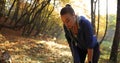 Female runner in the park. Close-up of tired young woman in fitness suit taking a break after long riun while sun shines