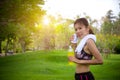 Female runner standing in park outdoors holding mineral water bottle, close up. Fitness athlete woman taking a break drinking Royalty Free Stock Photo
