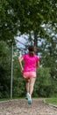 Female jogger on a track between trees