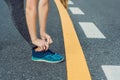 Female runner tying her shoes preparing for jogging outside .Young girld runner getting ready for training. Sport