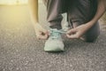 Female runner tying her shoes preparing for jogging outside .Young girld runner getting ready for training. Sport lifestyle