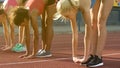 Female running team stretching and warming up, preparing for race, team spirit