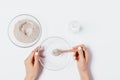 Female's hand adding spoonful of cosmetic clay powder