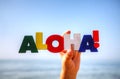 Female's hand holding colorful word 'Aloha'